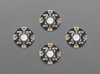 Overhead shot of four, black, round LED breakouts.