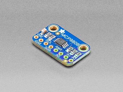 Angled shot of a small, blue, rectangular temperature sensor breakout board.