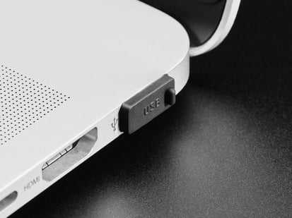 Close-up of a single black silicone USB A cover installed on a laptop's USB port.