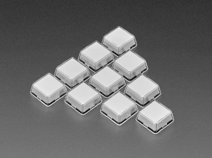 Angled shot of ten white plastic keycaps.