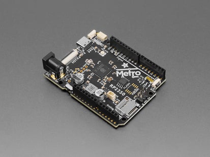 Angled shot of black, credit card-sized microcontroller with stacking headers.