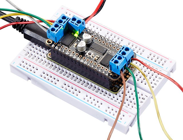 Top view of a DC Motor and Stepper FeatherWing plugged into a white breadboard.